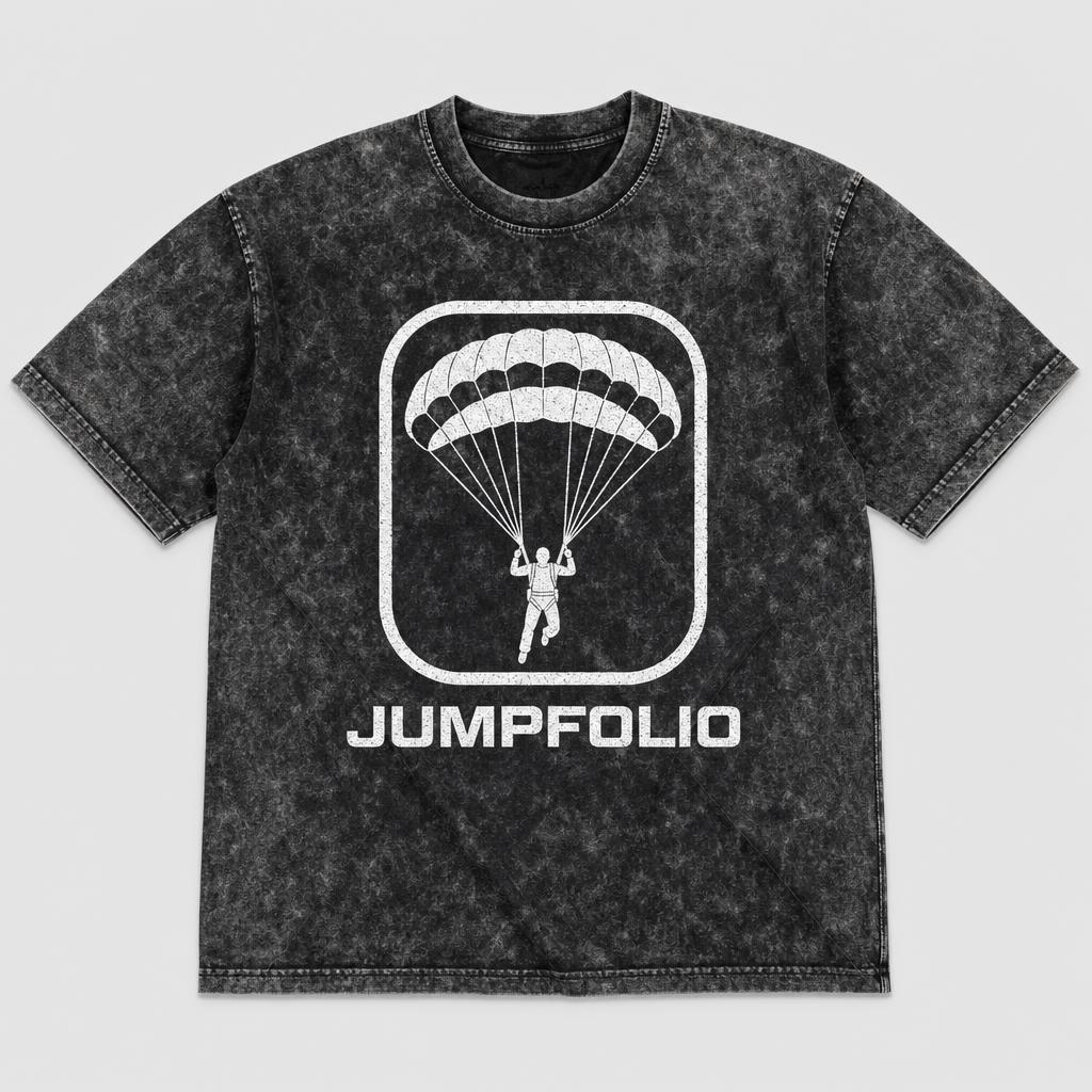 Acid-wash charcoal Jumpfolio t-shirt with a white skydiver-under-canopy emblem and JUMPFOLIO wordmark printed on the chest